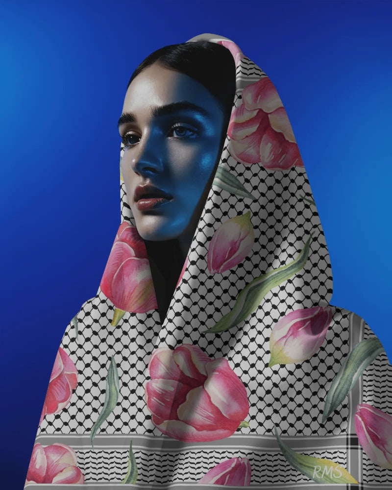 Person wearing a Palestinian floral headscarf with a blue gradient on a blue background