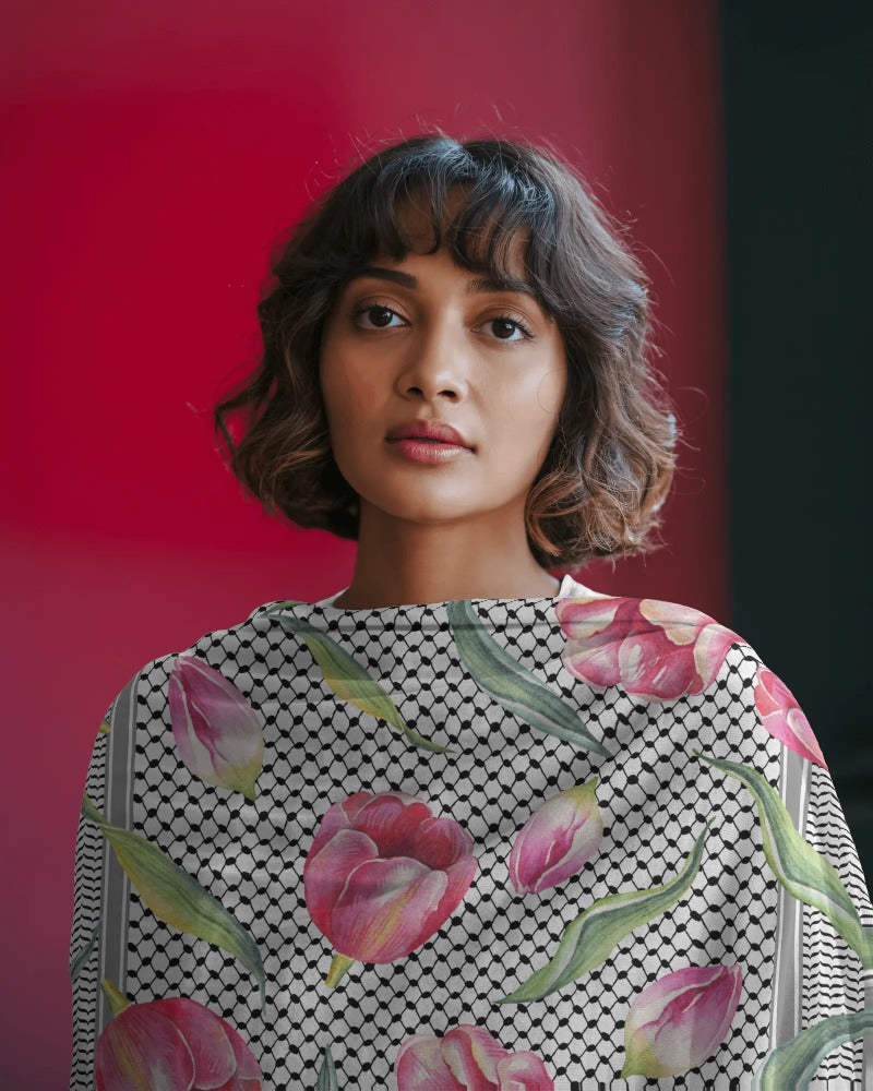 Woman wearing a patterned top with pink tulips against a red background
